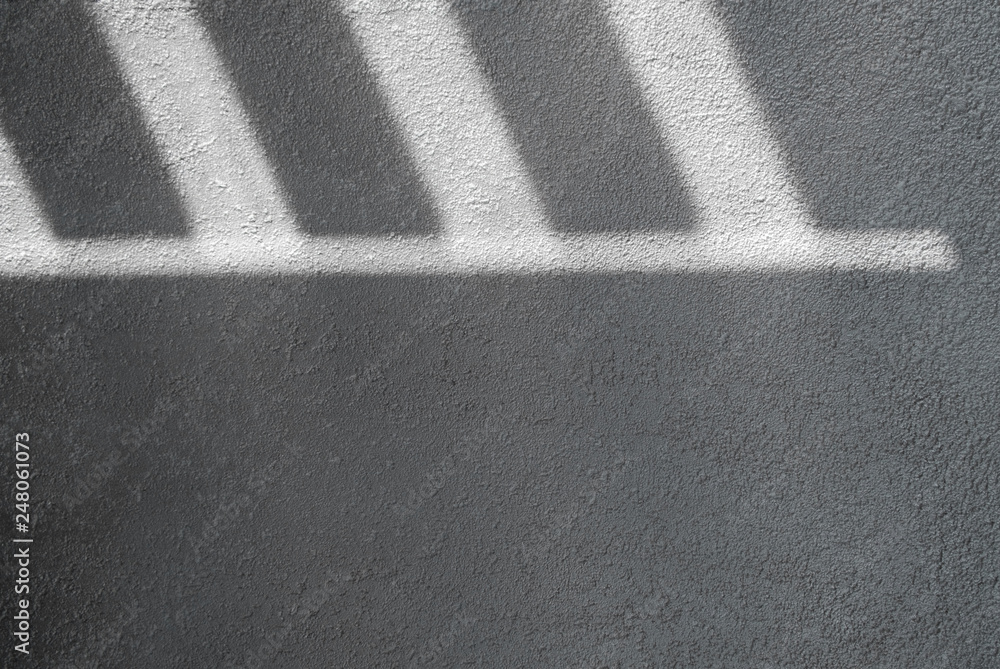 Fototapeta premium Shadow and light through blinds window on tiled wall. Abstract form morning light and shadow on the wall.