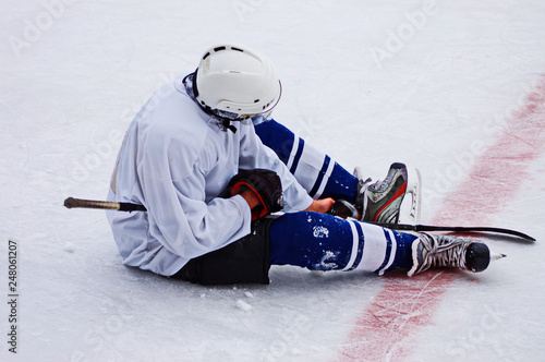 Photography Hockey player sitting on the ice with disappointment