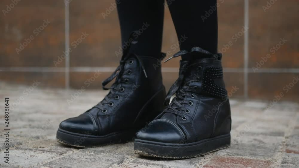 Female legs in boots on the sidewalk Female legs in boots on the sidewalk