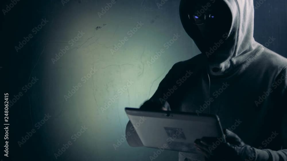 Hacker works with tablet while cracking system, close up. Hacker works with tablet while cracking system, close up.