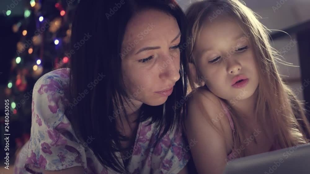 Funny mom and lovely daughter are having fun with tablet. Happy loving family. Funny mom and lovely daughter are having fun with tablet. Happy loving family.