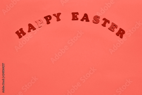 Easter background ispired by Living Coral. Letters forming words HAPPY EASTER in coral color. Copy space for your text. photo