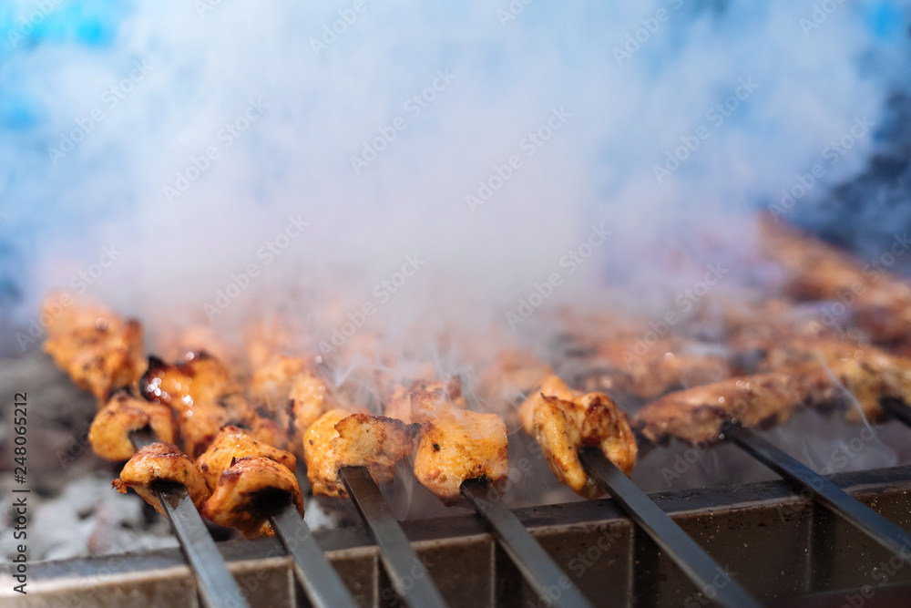 Chicken shish Kebab or kebap meat on metal skewer barbecue and embers in the Turkish restaurant. Skewering bbq Chicken Kebab.. Chicken shish Kebab or kebap meat on metal skewer barbecue and embers in the Turkish restaurant. Skewering bbq Chicken Kebab..
