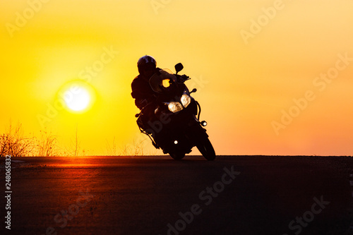 man on his motorbike riding into sunset