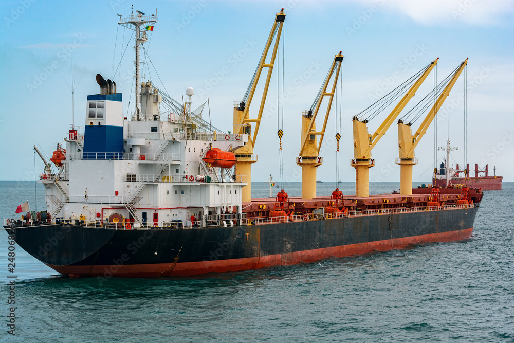 Big ore carrier vessel is awaiting loading of bauxite ore at outer anchorage of Kamsar port, Guinea, West Africa.