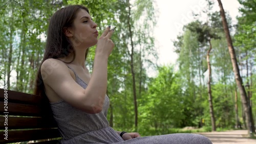 Pretty Girl Relaxing In The Park And Smoking Cigarette