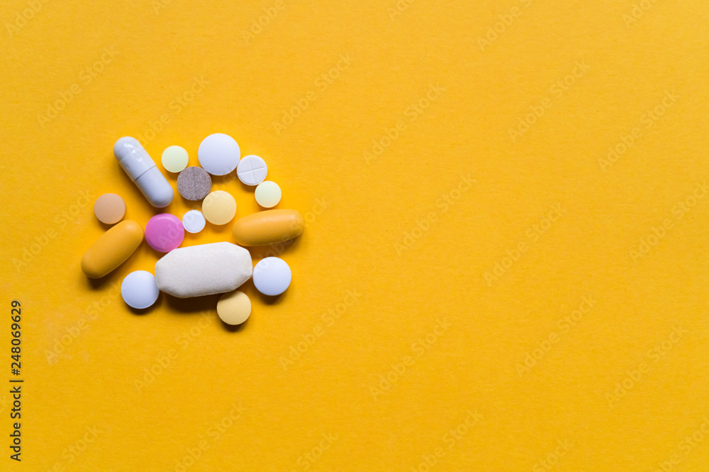 Colorful pills and drugs isolated on yellow background. Various kinds of medicine. Colorful pills and drugs isolated on yellow background. Various kinds of medicine.