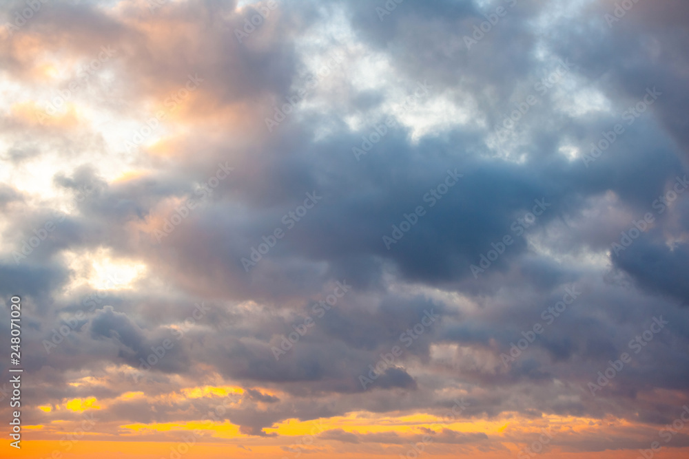 view of a warm orange sunset with clouds in pastel colors