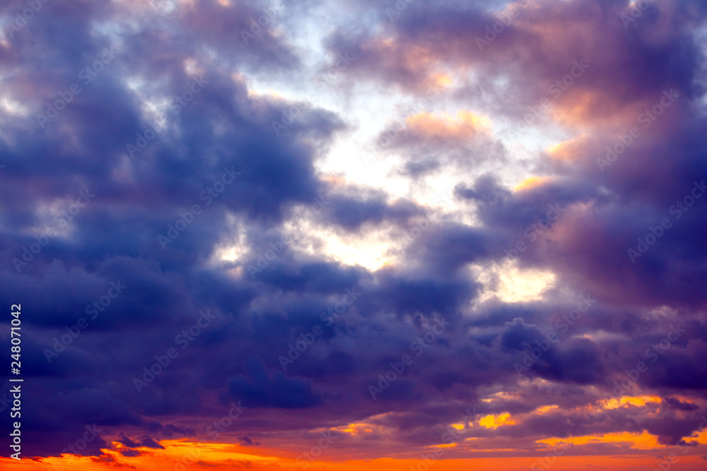 view of the bright orange sunset with purple and dark blue clouds
