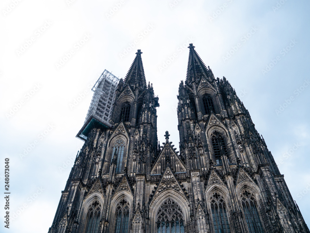 Cologne Cathedral with scaffold against cloudy sky