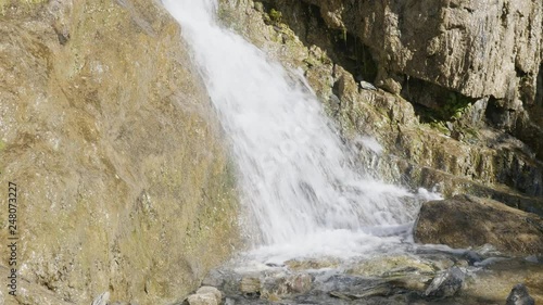 Big beautiful waterfall flows down the rocks mountains. photo