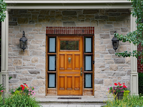 front door of stone house with wooden door and lion head knocker