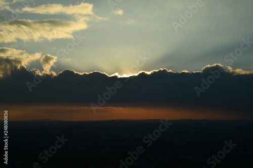 sunset in the mountains the sun has set behind a cloud and you can see bright rays of light © Andrey