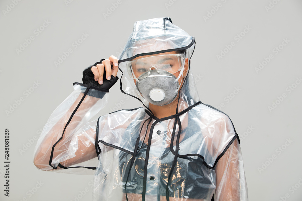 Asian Tan Skin Fitness woman exercise stretch arm running wear sport bra gloves transparent fashion raincoat pollution mask safety glasses, studio lighting gray background, concept future pollution Asian Tan Skin Fitness woman exercise stretch arm running wear sport bra gloves transparent fashion raincoat pollution mask safety glasses, studio lighting gray background, concept future pollution