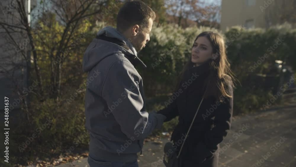 Man reconciling with his offended girlfriend, apologizing, couple hugging Man reconciling with his offended girlfriend, apologizing, couple hugging
