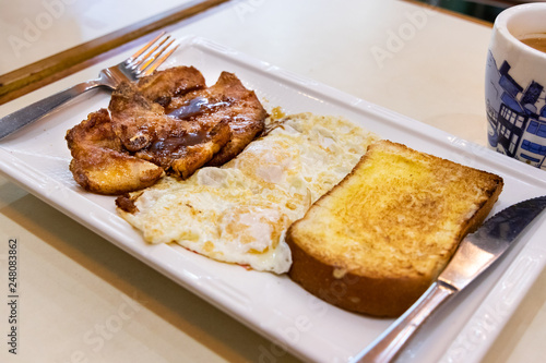 Simple pork chop, fried eggs, bread breakfast in Hong Kong