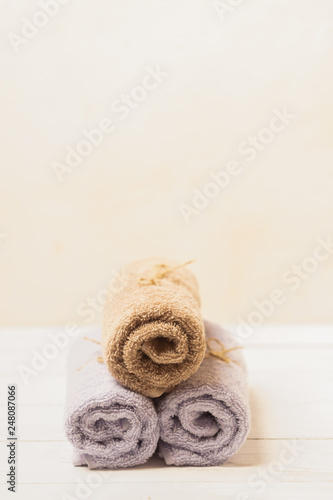 Clean soft towels tied with a natural rope and folded slide on a light background. Selective focus. Vertical frame.