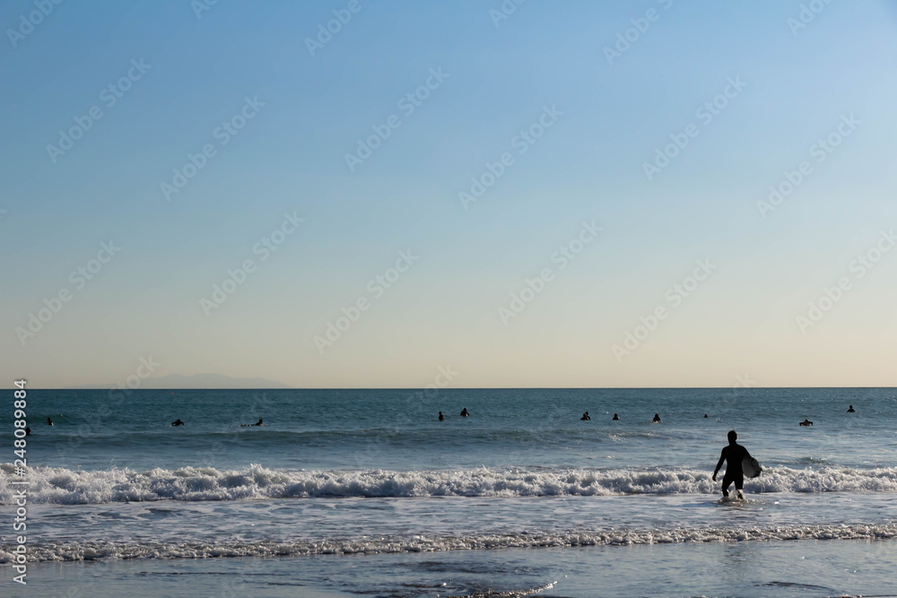 サーファーが波に乗る浜辺