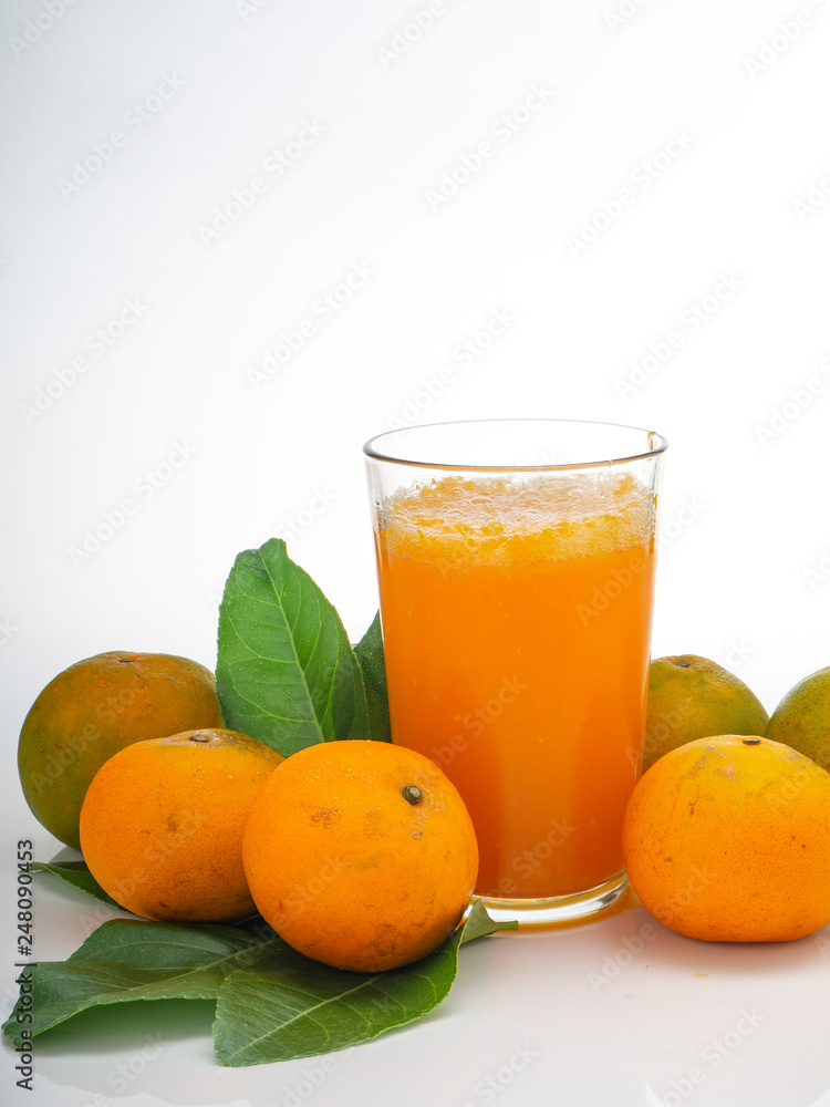 Glass with orange juice and fruits with green leaves Glass with orange juice and fruits with green leaves