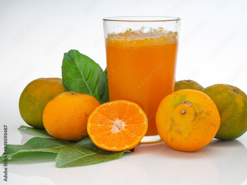 Glass with orange juice and fruits with green leaves Glass with orange juice and fruits with green leaves
