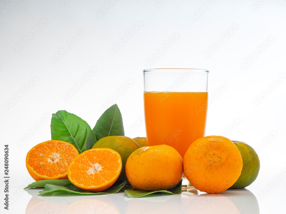 Glass with orange juice and fruits with green leaves Glass with orange juice and fruits with green leaves