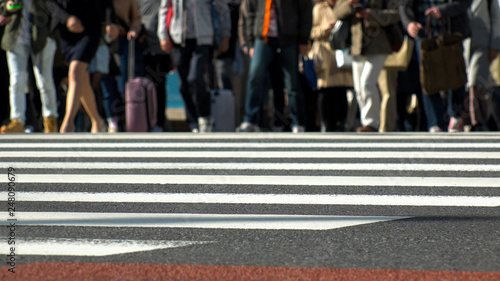 SHINJUKU, TOKYO, JAPAN - CIRCA MAY 2018 : Commuters and tourists at zebra crossing in front of SHINJUKU train station.