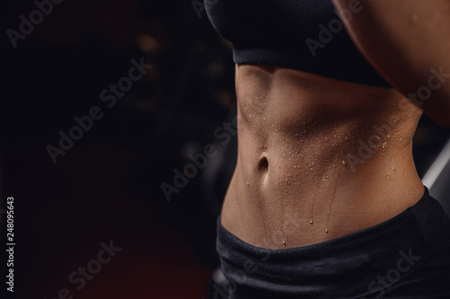 Inflated body fitness of young woman, abdominal muscles dices. Concept sweat after exercise photo
