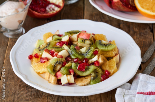 Salad with various fresh fruits on a white plate 