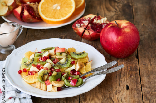 Salad with various fresh fruits on a white plate   