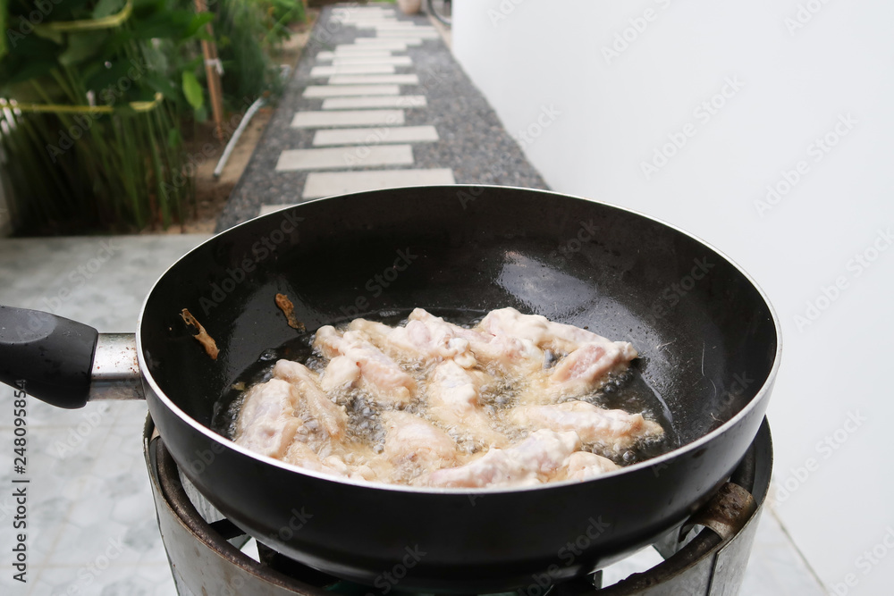 Chicken frying in a pan closeup, boiling oil. Chicken frying in a pan closeup, boiling oil.