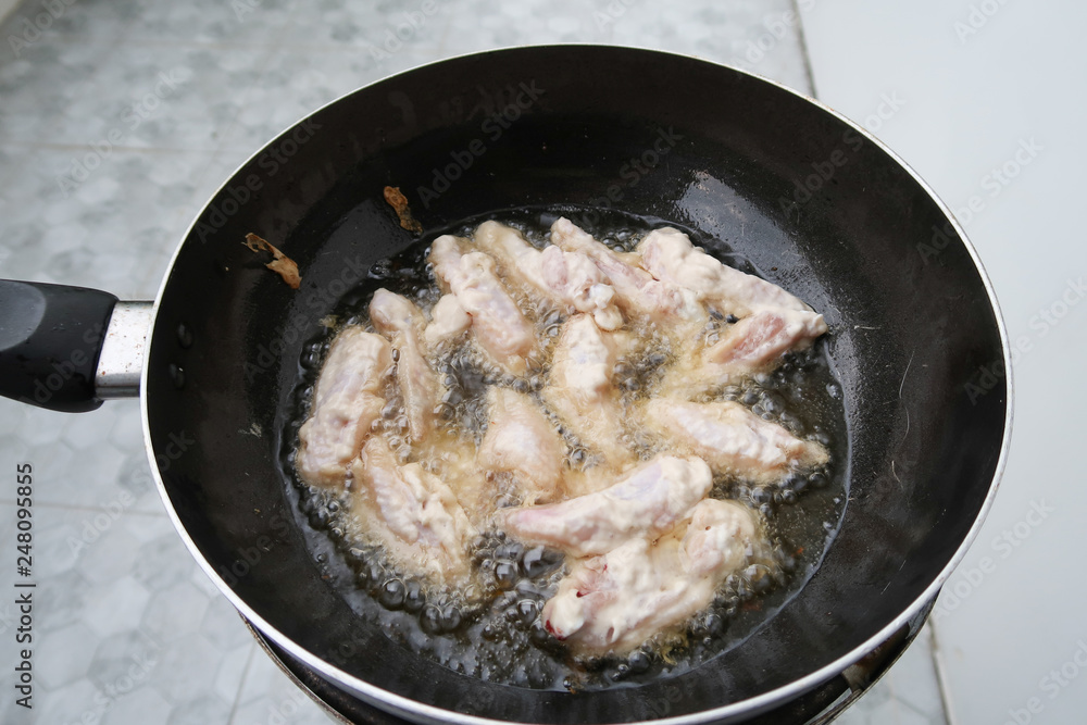 Chicken frying in a pan closeup, boiling oil. Chicken frying in a pan closeup, boiling oil.