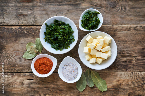 Various spices, fresh celery and butter on a wooden background
