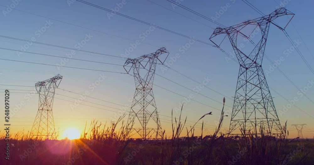 Time lapsed of electricity pylon on a field during sunset 4k