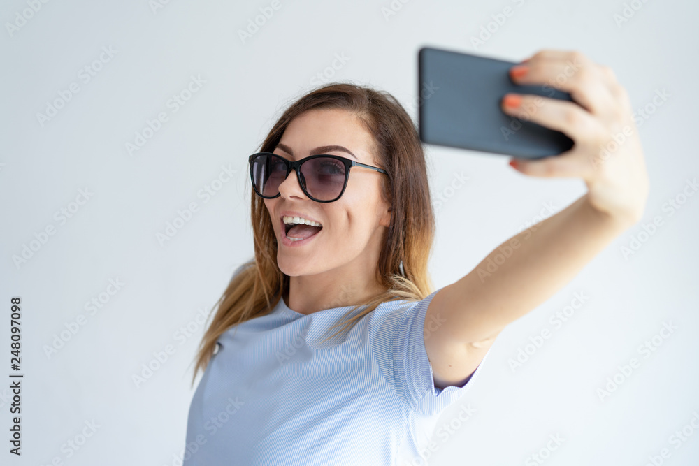 Cheerful woman taking selfie photo on smartphone Cheerful woman taking selfie photo on smartphone