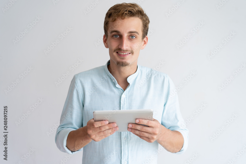 Positive young man holding tablet computer Positive young man holding tablet computer