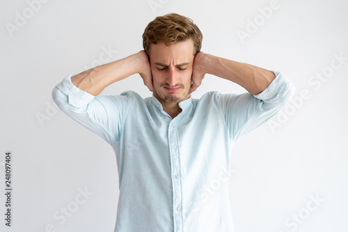 Fotografija Tensed man covering ears with hands with his eyes closed