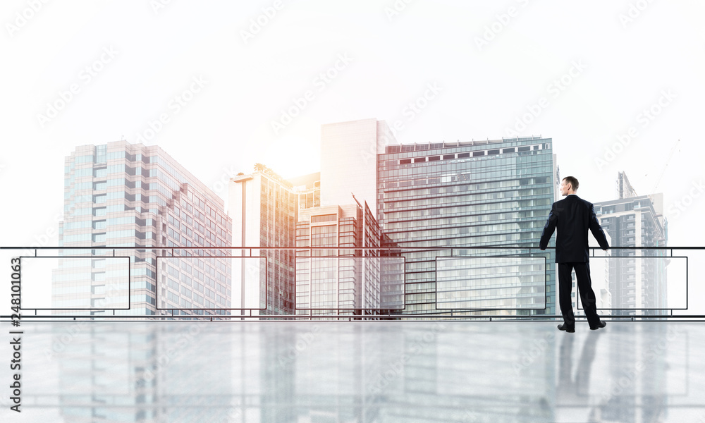 Sunrise above skyscrapers and businessman facing new day Sunrise above skyscrapers and businessman facing new day