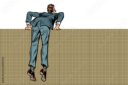 man climbs over wall