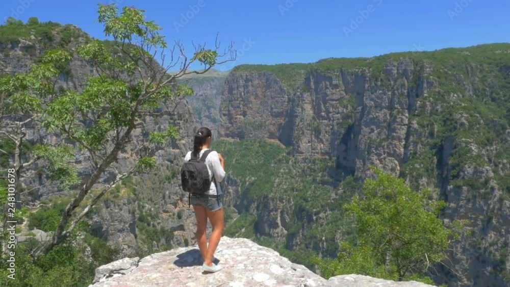 girl traveler with a backpack goes to the edge on top of a cliff. Woman Healthy Asset. Lifestyle girl traveler with a backpack goes to the edge on top of a cliff. Woman Healthy Asset. Lifestyle