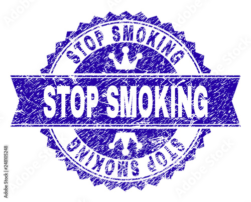 STOP SMOKING rosette seal watermark with grunge style. Designed with round rosette, ribbon and small crowns. Blue vector rubber watermark of STOP SMOKING tag with dirty style.