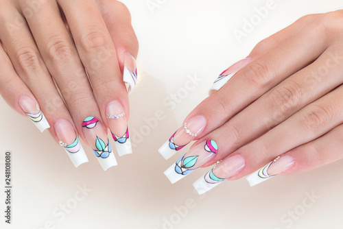 Manicure on nails isolated on cream background. Manicure with gems and sparkles. Trendy Accessories. Beauty hands. Stylish Nails