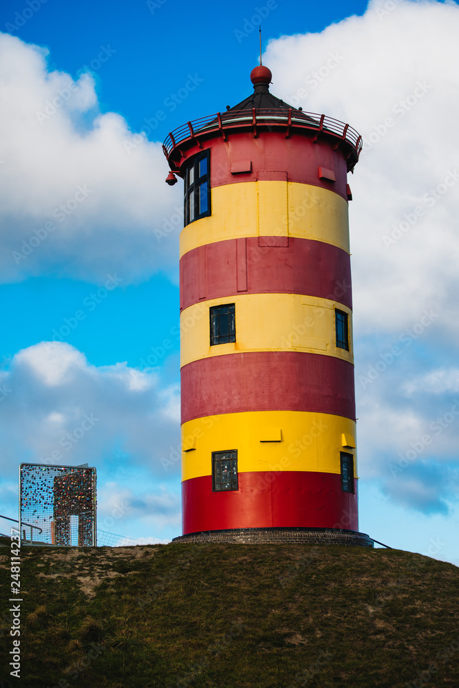 Pilsum Lighthouse on the North Sea in Germany. The red and yellow