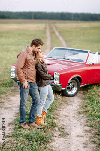 A man and a woman are not far from the retro car.
