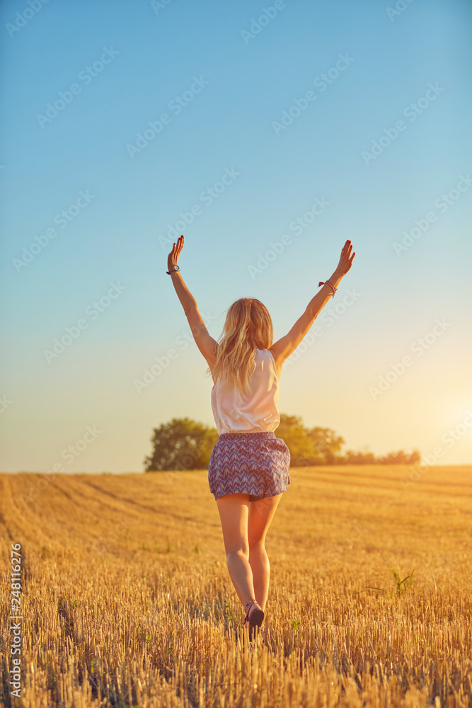 Cute young woman jumping in a wheat field. Cute young woman jumping in a wheat field.