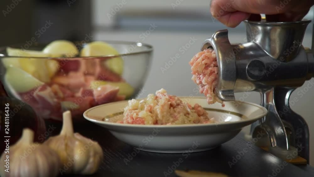 Man Puts Meat and Onion into the Meat Grinder Man Puts Meat and Onion into the Meat Grinder
