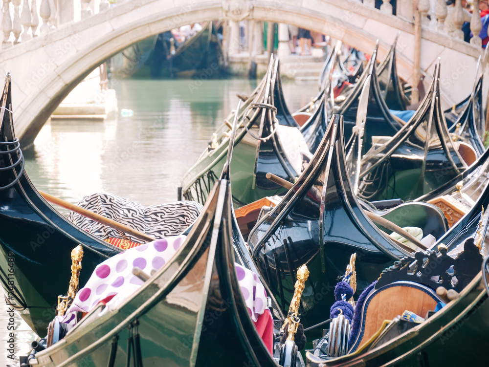 Group of traditional gondolas moored on narrow canal in Venice