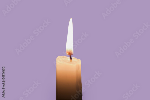 A burning candle isolated with light violet background