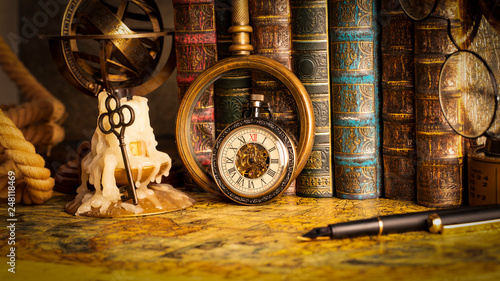 Antique clock on the background of a magnifying glass and books. Vintage style. 1565 old map of the year.