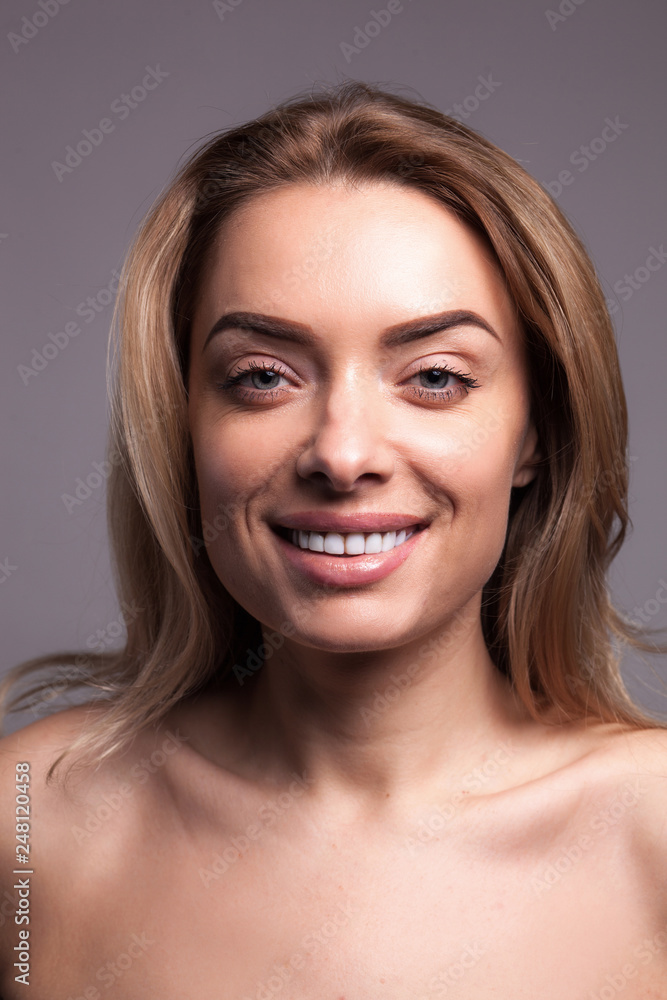 Fototapeta premium Adult beautiful blond woman with white veneers on the teeth.