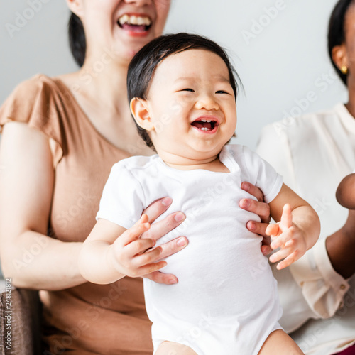 Cheerful baby being supported by her mom